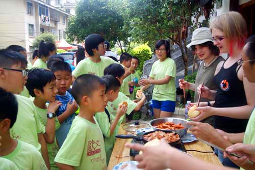 参加夏令营的学生看外教们自己动手做饭，语言交流在生活中发生